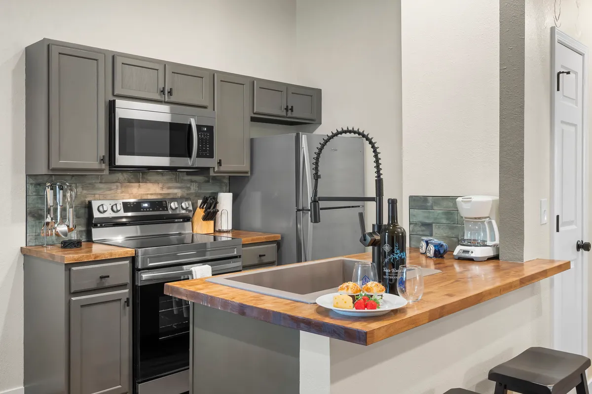 A stylish, fully-equipped kitchen with modern appliances and a welcoming atmosphere. A plate of snacks sits on the counter, hinting at easy entertaining and shared meals.