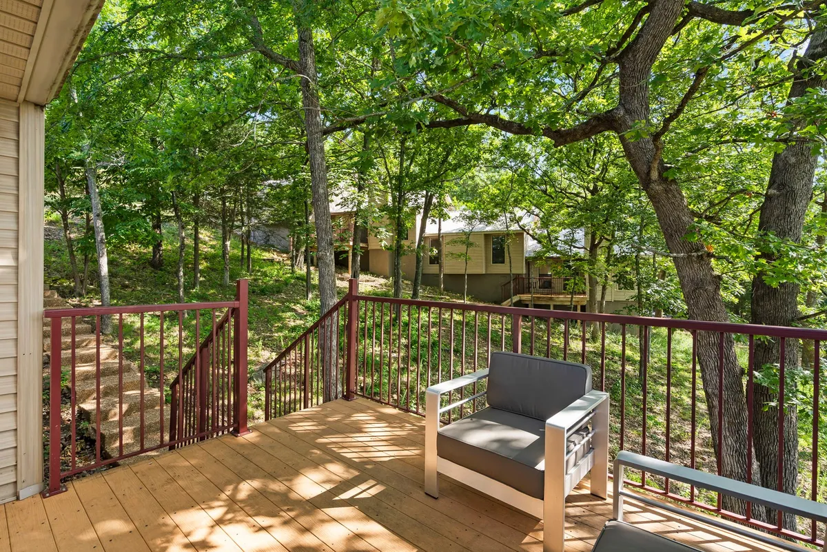 A peaceful wooden deck with comfortable outdoor seating surrounded by lush greenery, offering a relaxing space to unwind with nature close by. The deck is spacious and inviting, perfect for sipping coffee in the morning or letting a pet lounge while you take in the views.