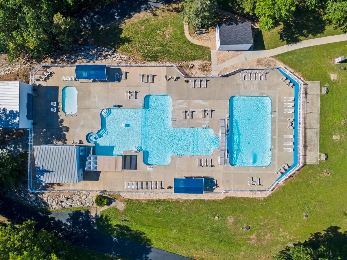 An inviting outdoor swimming pool lined with lounge chairs, surrounded by greenery. The atmosphere is leisurely and carefree, suggesting a place to cool off, splash around, and relax together during sunny afternoons.